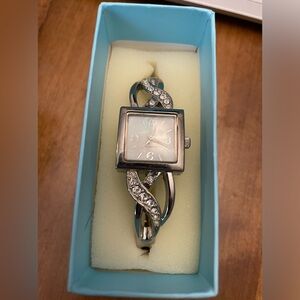 Avon rhinestone cuff watch in Silvertone and clear stone.